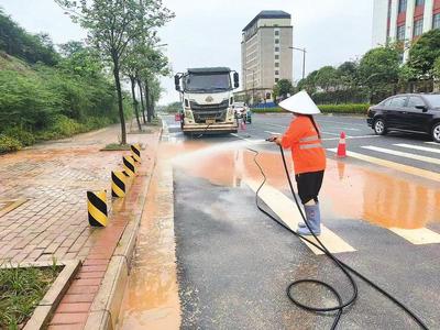 环卫工人对春阳路路面进行冲洗作业,助力恢复道路畅通。(周秀俊 摄)