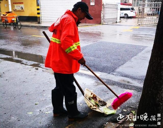 【清扫一科】环卫工人雨后清理积水落叶,确保道路干净整洁 .